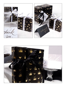 Detail of black and gold gift wrap showing crown and heart patterns on luxury boxes