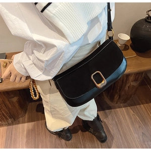 Detail showing a black PU leather crossbody bag with a gold rectangular metal buckle