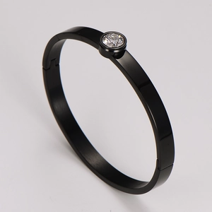 Macro shot of minimalist black stainless steel bangle with a sparkling clear zircon stone