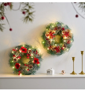 Close-up of pine needle Christmas wreath with red berries, pinecones and warm LED lights