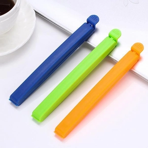 Three colorful plastic food bag sealer clips in blue, green, and orange for snack storage
