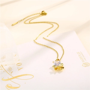 Collana a fiocco dorata con pendente in zirconia su un espositore regalo elegante