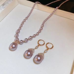 Gros plan d'un ensemble collier et boucles d'oreilles en perles roses et dorées