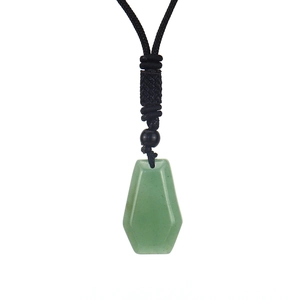 Macro detail of hexagonal light green stone pendant with black braided cord necklace