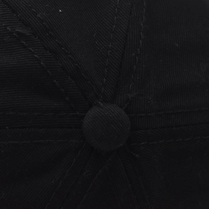 Detailed macro view of the black cotton baseball cap top button and six-panel stitching