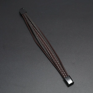 Detailed view of dark braided leather strands and black magnetic clasp on men's bracelet