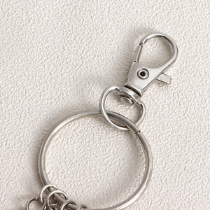Detailed macro view of silver metallic lobster clasp and large split ring hardware