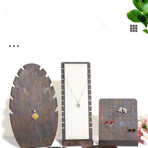 Macro detail of vintage wooden jewelry display set featuring necklace and earring stands