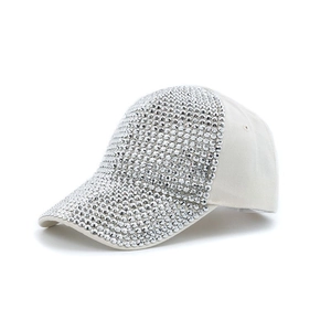 Close-up of sparkling silver rhinestones on a white breathable baseball cap surface