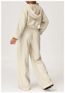 Rear view of woman in beige high-waisted wide-leg sweatpants and matching cropped hoodie