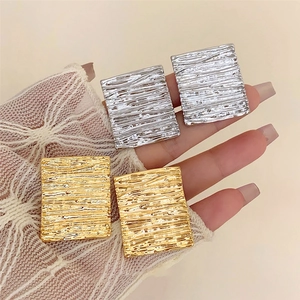 Minimalist geometric square earrings with fluid gold and silver rippled metal textures