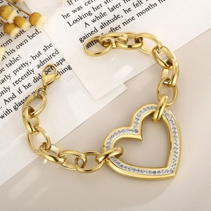 Macro view of gold chunky chain bracelet featuring a sparkling rhinestone heart pendant