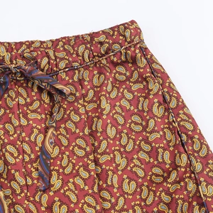 Detail of adjustable drawstring waist on burgundy paisley printed trousers