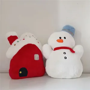 Close-up of red snow-roof house and white snowman plush holiday decorative pillows