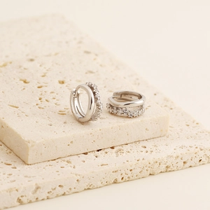 Macro shot of silver S925 earrings with double-hoop design and sparkling cubic zirconia