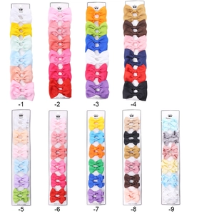 Detail showing various colors of ribbed ribbon bow hair clips on white display cards