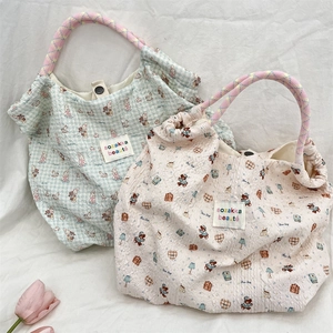 Detail of cartoon printed canvas tote bag with textured fabric and woven rope handle