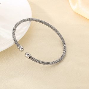 Detail view of silver mesh woven stainless steel cable bracelet with polished sphere ends