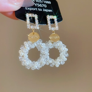 Detailed shot of 925 silver earrings with square crystals and pearl pendant drops