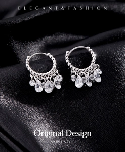 Macro detail of S925 sterling silver hoop earrings with shimmering tassel zircon drops