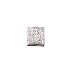 Macro detail of silver book-shaped locket pendant with tree of life relief on white base