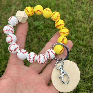 Makroaufnahme von Baseball-Perlen mit Holzanhänger an einem silbernen Schlüsselring