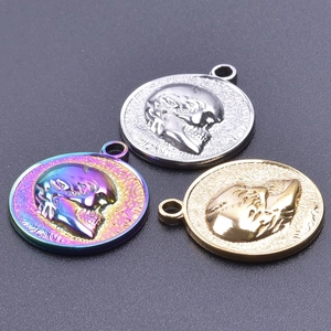 Macro detail of round skull relief pendants in gold, silver, and rainbow finishes