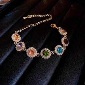 Gros plan d'un bracelet en cristal coloré avec dorure et fermoir réglable sur cuir noir