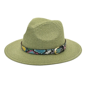Detail of olive green straw fedora featuring a colorful snakeskin band and gold buckle