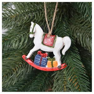 Detail of white rocking horse Christmas tree ornament with colorful gifts on pine branch
