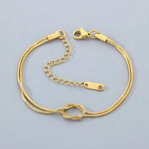 Detail of gold double-layered snake chain bracelet with knot charm and S.STEEL stamp