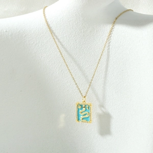 Detail of 18k gold plated tarot necklace featuring a blue enamel snake pendant with zircons