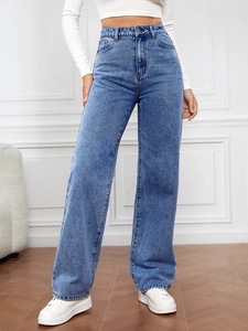 Détail de ce jean taille haute à jambe large montrant le délavage et les coutures