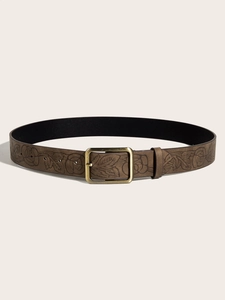Close-up of brown vintage belt with embossed floral patterns and bronze square buckle