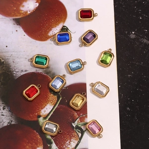 Detailed macro view of rectangular 18K gold plated pendants with colorful gemstones
