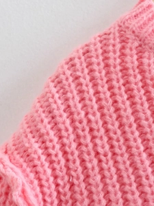 Vista macro dettagliata della trama a maglia a coste rosa acceso e del filato grosso sulla maglia