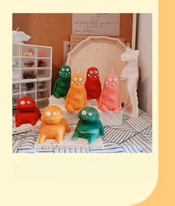 Vista dettagliata di candele a mostro colorate e stampi in silicone su un supporto di pietra