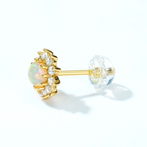Detail of golden sunburst stud earring with opal center and small diamond accents