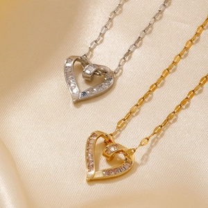 Close-up of gold and silver heart pendants with cubic zirconia on champagne silk