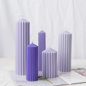 Vertical striped cylindrical scented candle set in purple hues with pointed tops