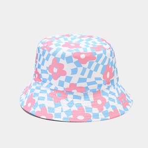 Détail d'un chapeau bob à carreaux bleus avec des motifs de fleurs roses