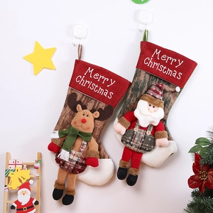 Detail of Christmas stockings with 3D Santa and reindeer hanging on a festive white wall