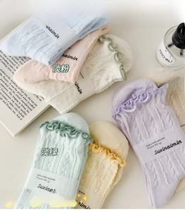 Detailed view of pastel mesh crew socks with ruffle cuffs and cable knit texture