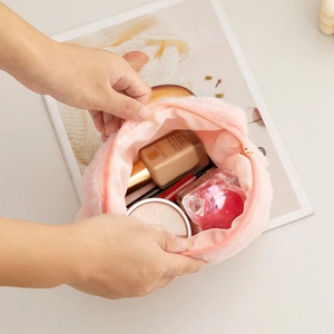 Internal view of a plush pink cosmetic bag showing spacious storage for makeup items