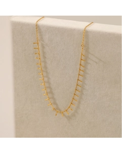 Detail of 18K gold plated titanium necklace with rectangular bar pendants on display
