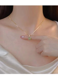 Détail du pendentif sac de chance en calcédoine vert clair sur une fine chaîne dorée pour femme