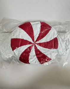 Detail eines Pfefferminz Plüschkissens mit rot-weißem Spiralmuster in der Verpackung