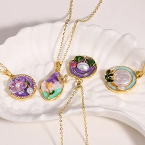 Detail of elegant gold necklaces with enamel flower charms and freshwater pearls