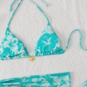 Detail of floral bikini top with hibiscus print and decorative golden flower buckle