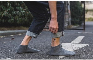 Detail view of dark grey cotton low-cut ankle socks with vertical striped knit texture